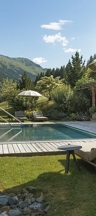 liegen und outdoor-pool mit aussicht auf die berge im luxuschalet die schmiedalm in österreich