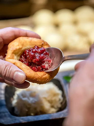 Ein Krapfen mit Preiselbeerenmarmelade in der Schmiedalm