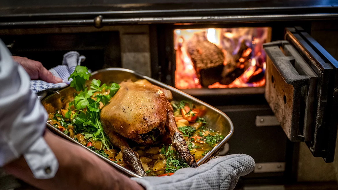 A deliciously stuffed roast is taken out of the wood-fired oven at the Schmiedalm